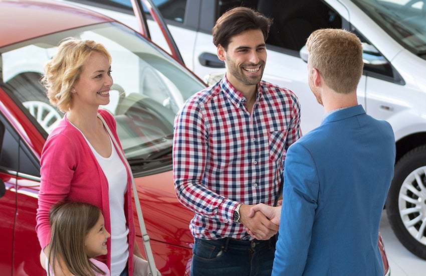 Customers shaking hands with the sales manager after buying a car from Criswell Chevrolet Gaithersburg
